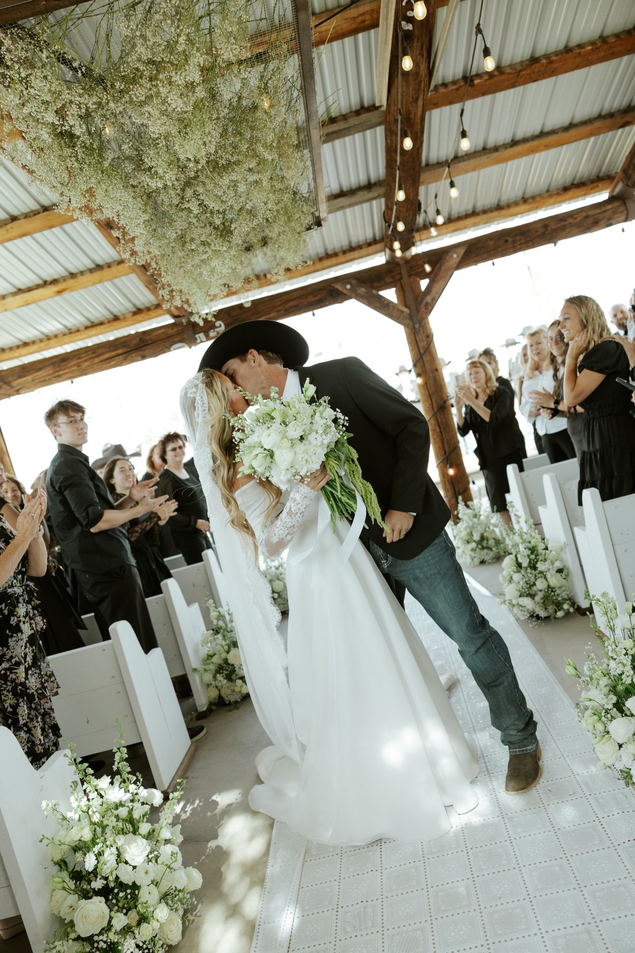 Arizona wedding ceremony with handcrafted white wooden pews from Borrow Bloom lining the aisle